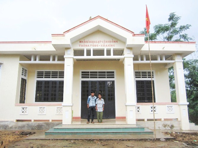 Nhà cộng đồng thôn A Tông khang trang trên mảnh đất do ông Ăm Tứt (phải) hiến tặng