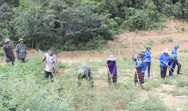 Bộ đội và thanh niên tình nguyện giúp dân làm đất để trồng cây