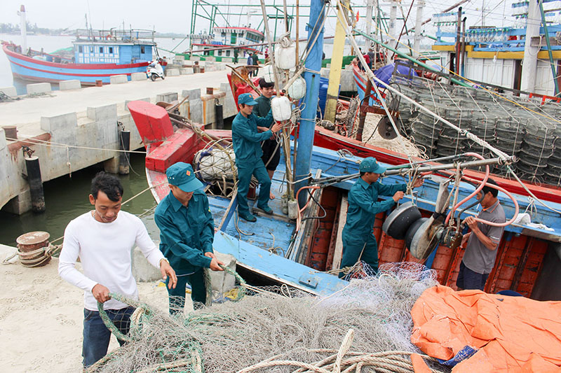 Lực lượng dân quân biển xã Triệu An, huyện Triệu Phong giúp ngư dân chuẩn bị ngư cụ để vươn khơi