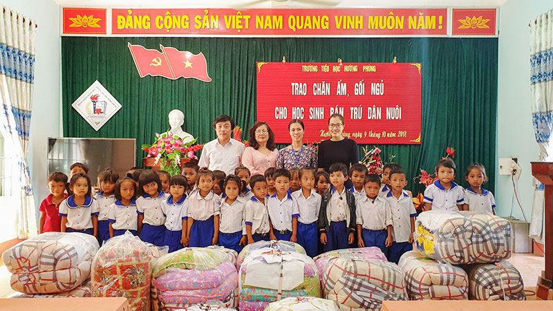 Chị Thảo Vân (thứ 2 từ trái sang) chụp ảnh kỷ niệm với giáo viên và học sinh Trường Tiểu học Hướng Phùng
