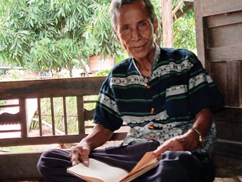 Thầy Lai (thôn Pa Hy, xã Tà Long, huyện Đakrông, tỉnh Quảng Trị) xem lại cuốn sổ ghi chép ngày xưa mình từng làm thầy giáo