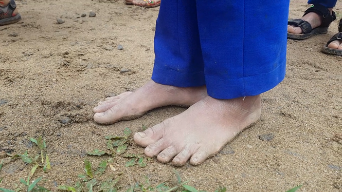 Đôi chân trần nhợt nhạt bùn đất giữa sân trường của một em học trò ở bản Toa Roa (xã Hướng Lộc, H.Hướng Hóa, Quảng Trị).