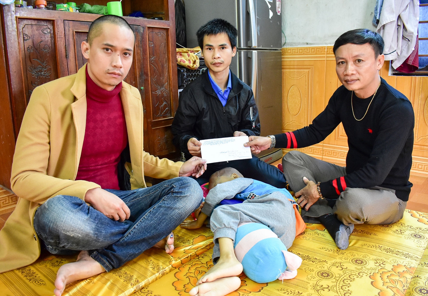 Đại diện Công ty XKLĐ Hoàng Ngọc Việt trao 5 triệu đồng cho gia đình em Bùi Văn Khoa