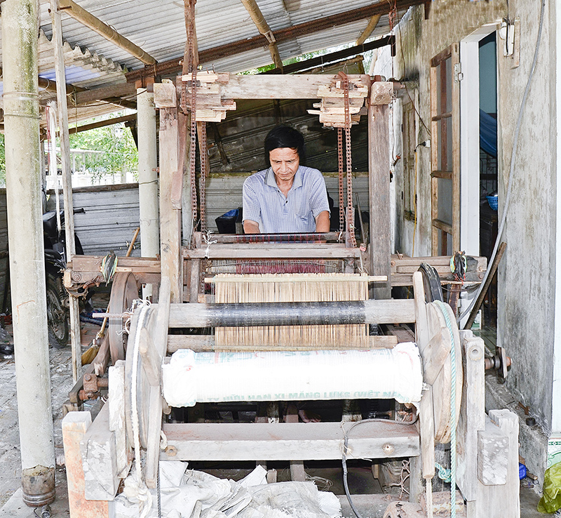 Ông Truyền bên khung dệt xăm lưới đã được cải tiến