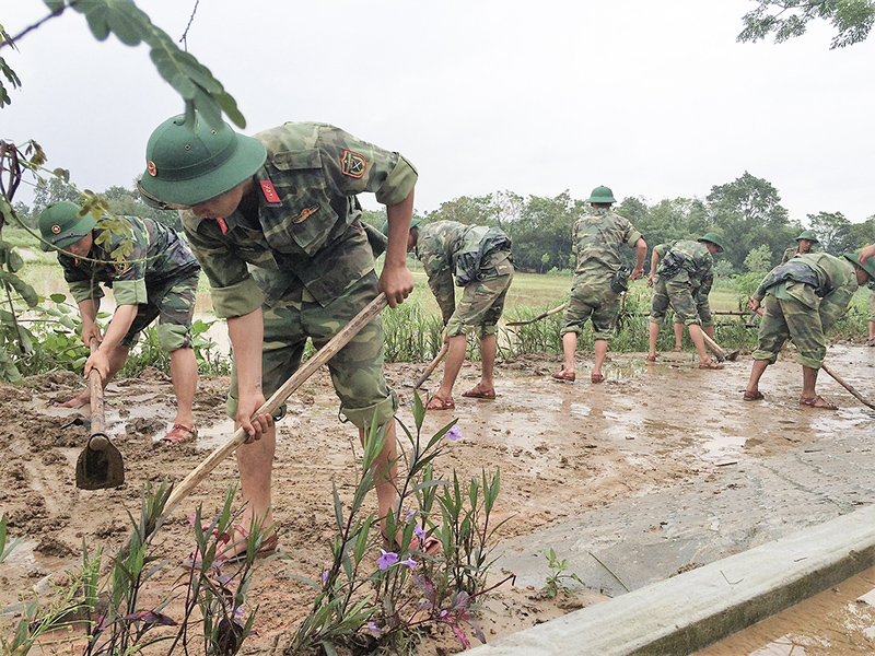 Bộ đội giúp dân khôi phục đường giao thông nông thôn sau lũ. Ảnh: PV