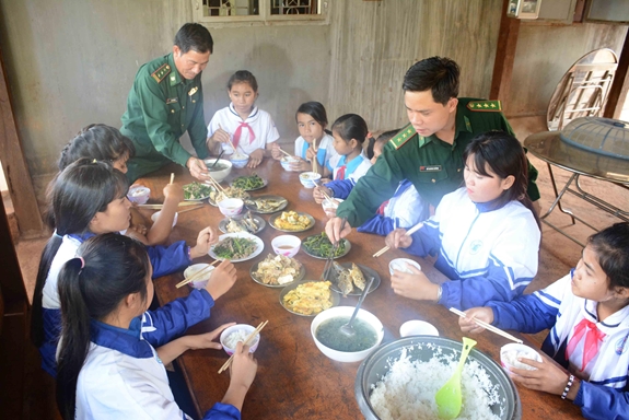 Đồn Biên phòng 721 (BĐBP tỉnh Gia Lai) tổ chức bữa cơm tình thương, giúp các học sinh nghèo thêm yên tâm tới trường. Ảnh: Quang Hồi