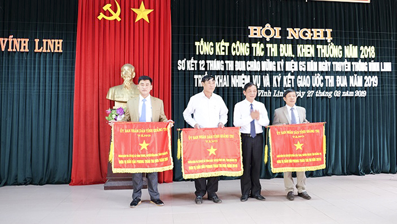 Đồng chí Phan Ngọc Tư, Bí thư Huyện ủy, Chủ tịch HĐND huyện trao Cờ thi đua của UBND tỉnh cho các xã Vĩnh Trung, Vĩnh Chấp và thị trấn Cửa Tùng​
