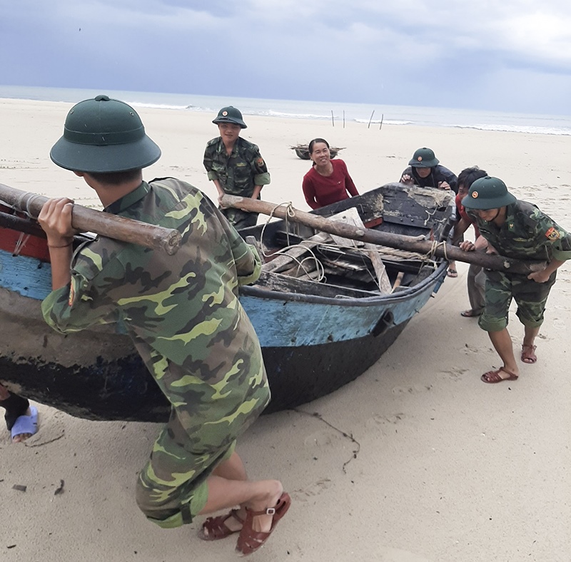 Cán bộ, chiến sĩ Đồn Biên phòng Cửa khẩu Cảng Cửa Việt giúp ngư dân đưa thuyền vào bờ trong mùa mưa bão