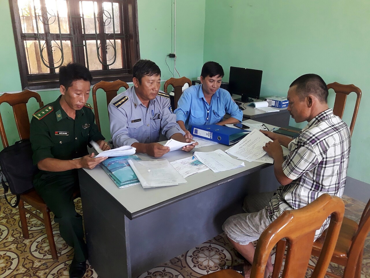 Cán bộ Văn phòng IUU tại Cảng cá Cửa Việt hướng dẫn chủ tàu cá nộp nhật kí khai thác