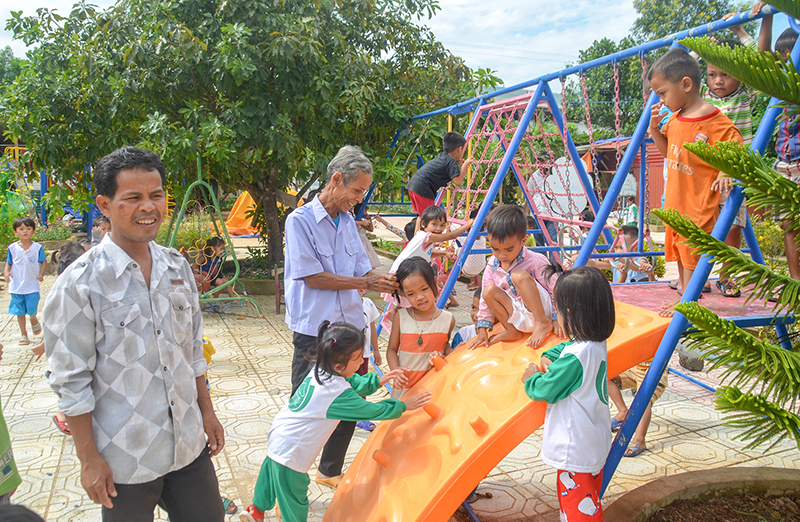 Niềm vui của anh Hồ Thanh Cang (phía trái ảnh) khi chứng kiến con em vui đùa, học tập tại điểm trường Mầm non Pa Hy do anh 2 lần hiến đất xây dựng nên​