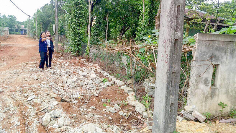 Bà Sen(bên trái) bên phần đất và bức tường rào của gia đình đã hiến để mở đường​