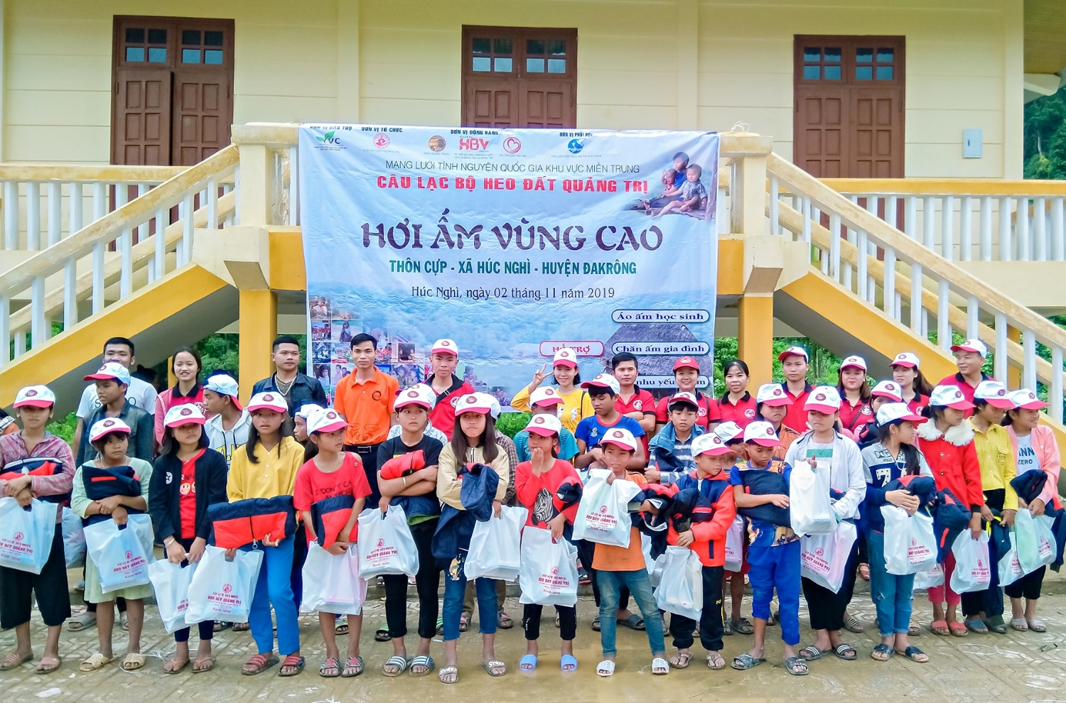 Các tình nguyện viên trao quà cho học sinh thôn Cựp​