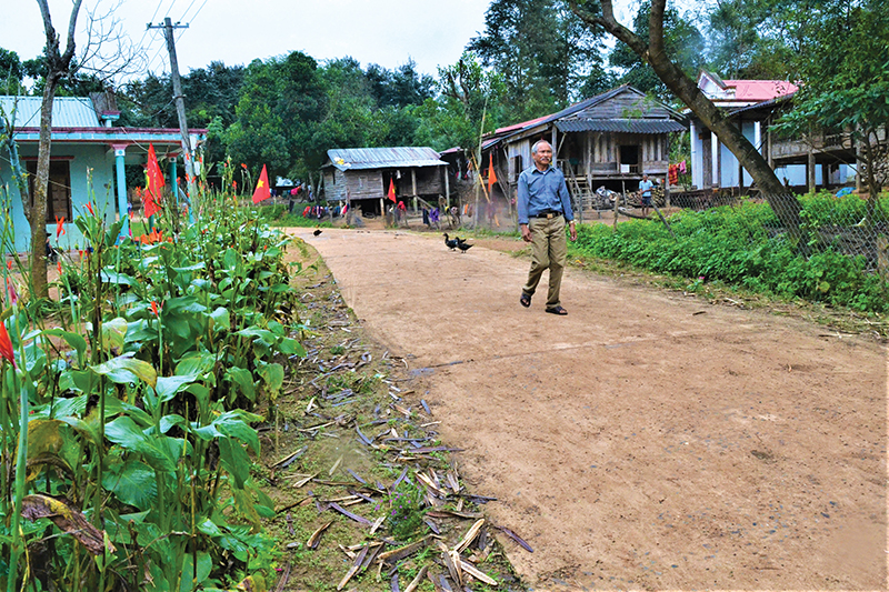 Ông Hồ Văn Dăm thường xuyên đi đến tận từng hộ gia đình trong bản để hướng dẫn cách trồng cây bời lời đỏ giúp bà con thoát nghèo. Ảnh: H.T