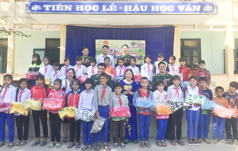 Trao áo ấm cho các em học sinh Trường PTDT Bán trú dân nuôi xã Ba Nang. Ảnh: N.B