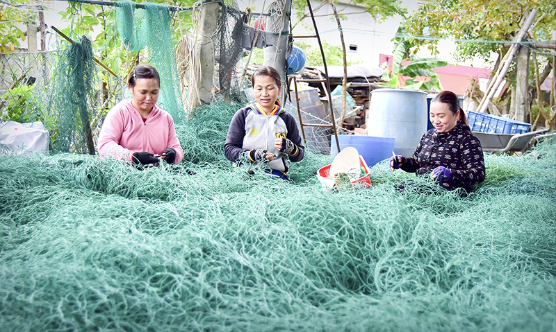 Đội phụ nữ vá lưới miệt mài làm việc. Ảnh: TT