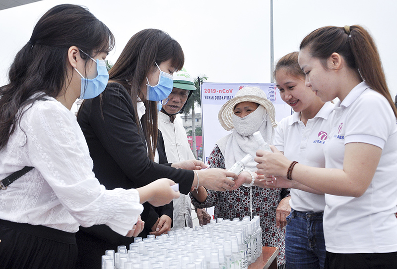Giảng viên Phân hiệu Đại học Huế tại Quảng Trị phát miễn phí nước rửa tay khô phòng COVID-19 cho người dân. Ảnh: T.L