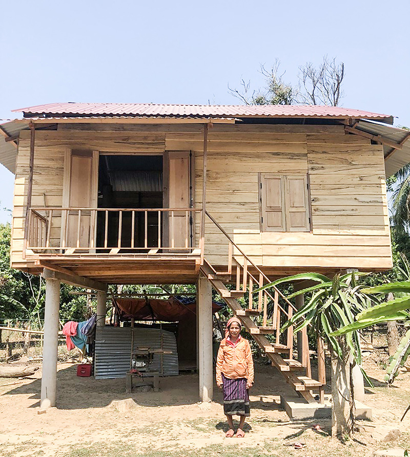 Bà Hồ Thị Tiềng bên ngôi nhà sàn mới được xây dựng - Ảnh: T.L​