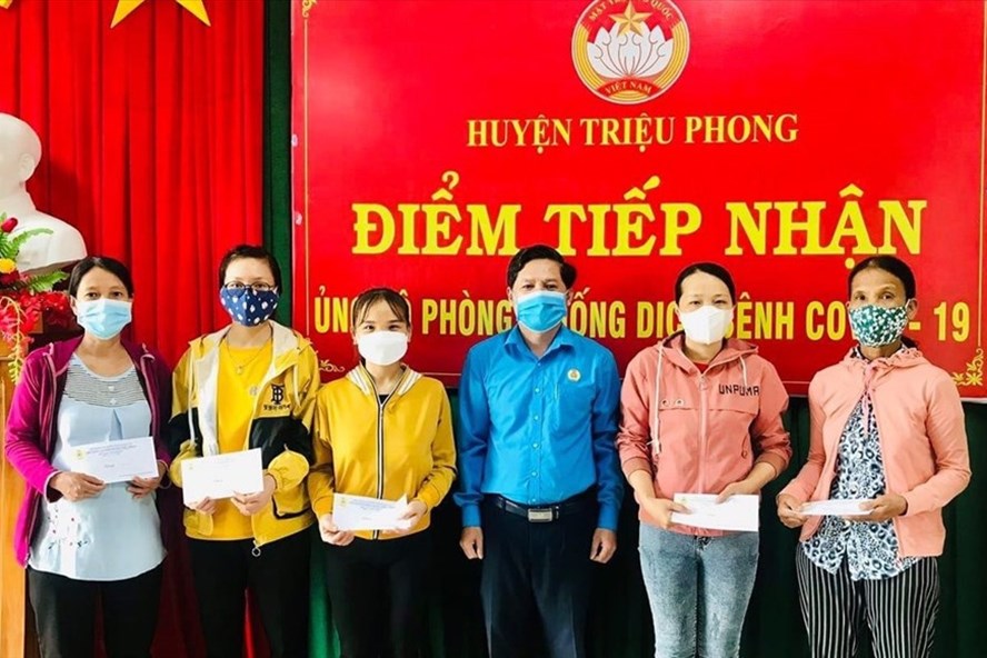 Thừa ủy quyền của LĐLĐ tỉnh, lãnh đạo LĐLĐ huyện Triệu Phong trao tiền hỗ trợ cho đoàn viên, người lao động trở về từ các tỉnh phía Nam có hoàn cảnh khó khăn. Ảnh: TD.