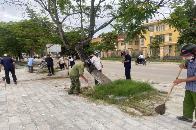 Cán bộ, Nhân dân phường 2 ra quân dọn dẹp vệ sinh môi trường. Ảnh XT