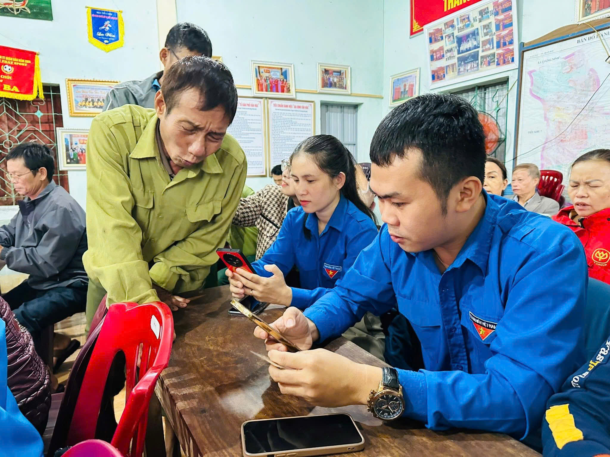 Đội hình thanh niên tình nguyện xã Quảng Ninh hỗ trợ người dân cài đặt sổ tay sức khoẻ điện tử- Ảnh: BBT