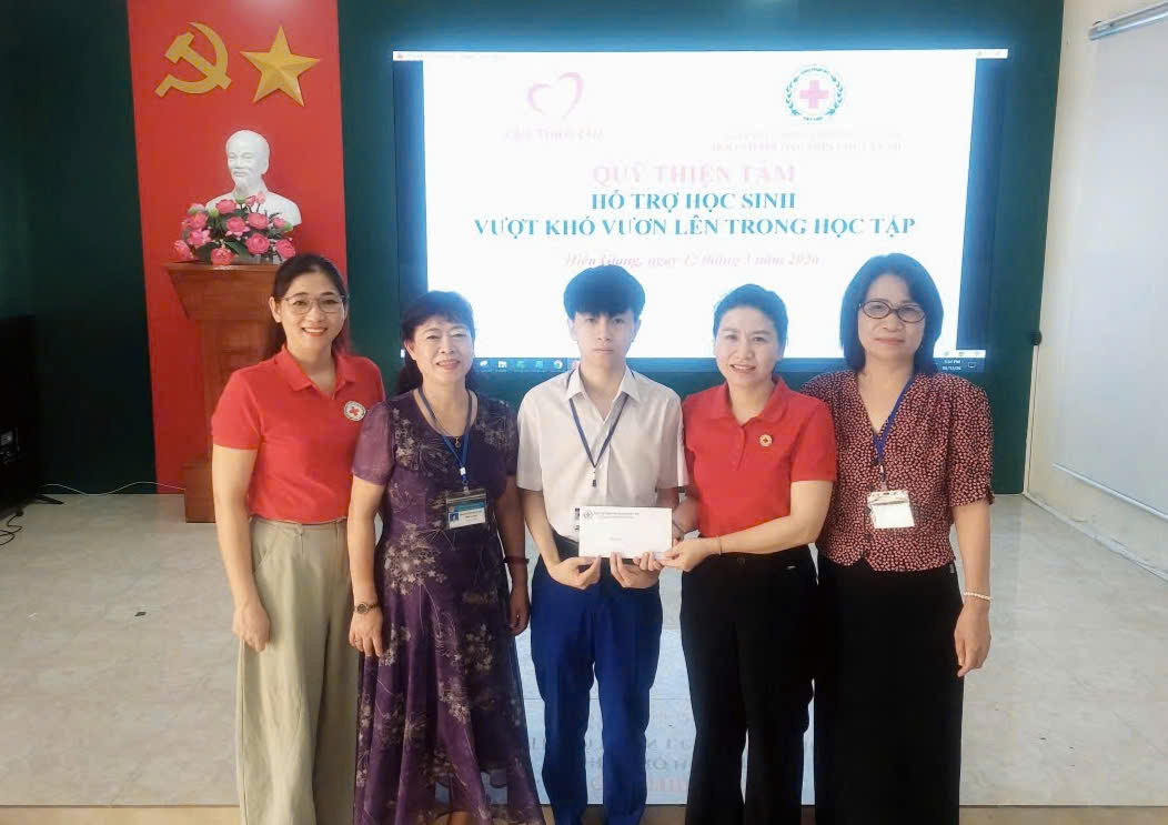 Bà Mai Thị Kim Nhung - Chủ tịch Hội Chữ thập đỏ tỉnh trao tiền hỗ trợ từ Quỹ Thiện Tâm cho các em học sinh