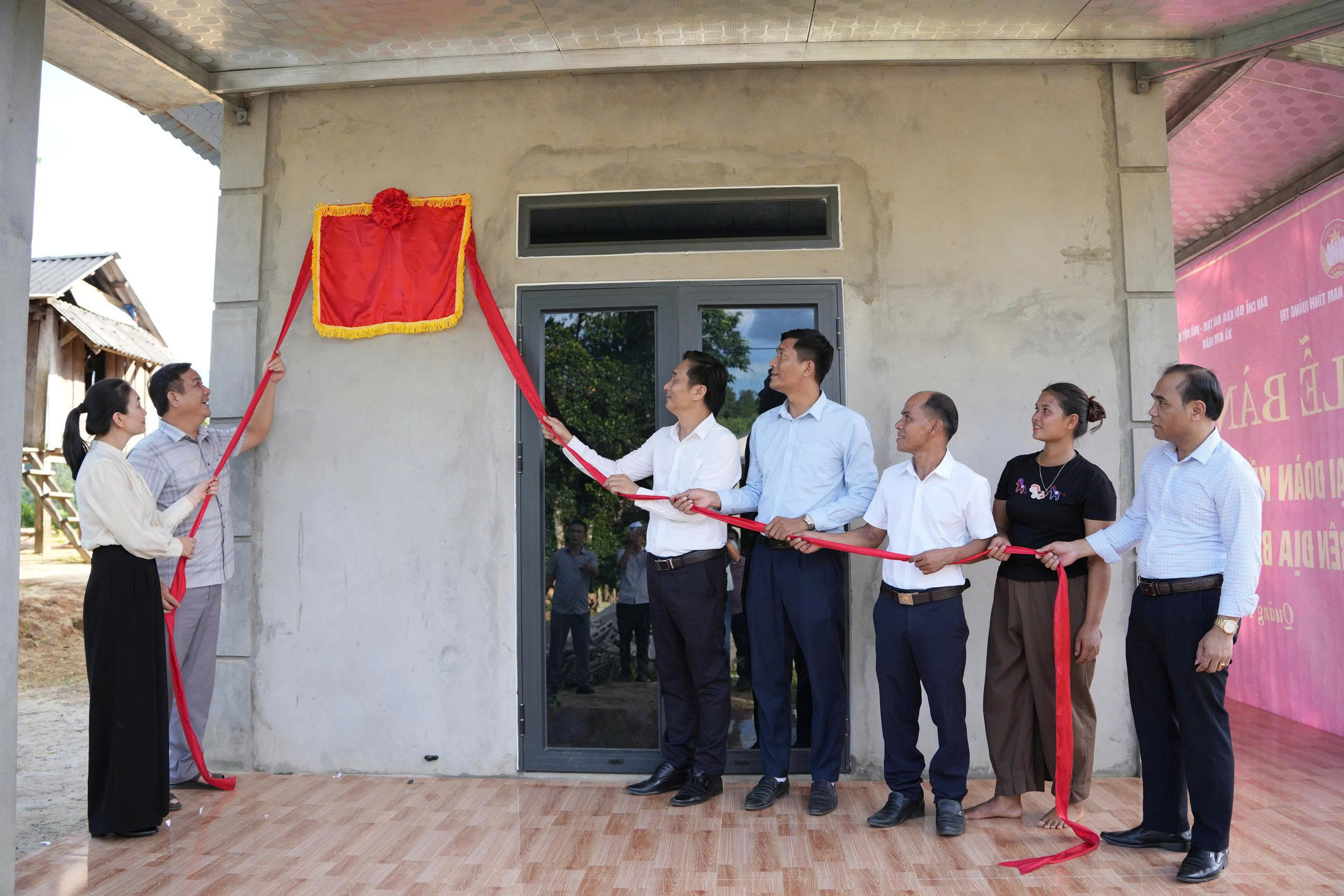 Các đại biểu cùng gia đình thực hiện nghi thức khánh thành nhà Đại đoàn kết